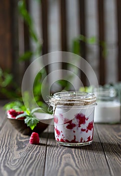 Raspberry smoothie, milkshake in a glass jar on a dark wooden background. Yogurt cocktail. Natural summer detox drink