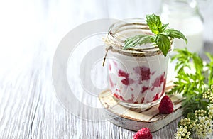 Raspberry smoothie, milkshake in a glass jar on a light background. Yogurt cocktail. Natural summer detox drink