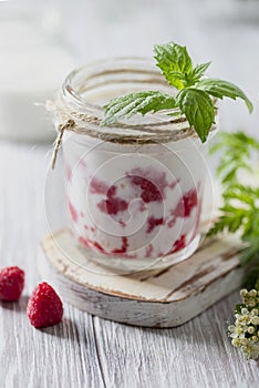 Raspberry smoothie, milkshake in a glass jar on a light background. Yogurt cocktail. Natural summer detox drink