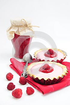 Raspberry tarts and jar of raspberry jam