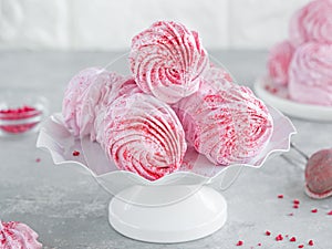 Raspberry zephyr, Russian marshmallows on a cake stand on a grey concrete background. Copy space, selective focus