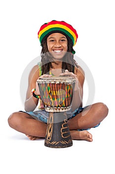 Rasta man sitting on the floor and beat a drum