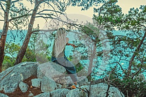 rastafarian girl with dreadlocks smoking on the mediterranean coast