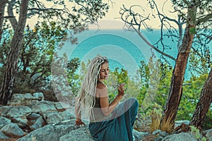 rastafarian girl with dreadlocks smoking on the mediterranean coast