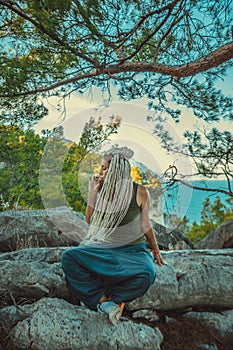 rastafarian girl with dreadlocks smoking on the mediterranean coast