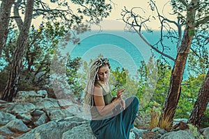 rastafarian girl with dreadlocks smoking on the mediterranean coast