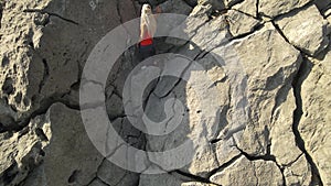 a rastafarian girl with dreadlocks walks on the rocks