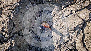 a rastafarian girl with dreadlocks walks on the rocks