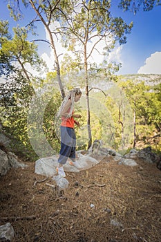 Rastafarian girl on a walk in a rocky forest