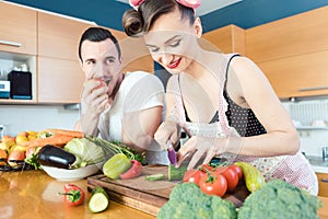 Rather lazy man Is watching his wife preparing the food