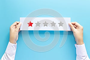 Rating and feedback concept. customer holding paper with poor satisfied review by give one star for service experience.