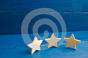 The rating of the hotel, restaurant, mobile application. Three stars on a blue background. The concept of rating and evaluation.
