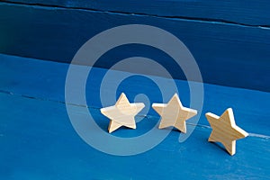 The rating of the hotel, restaurant, mobile application. Three stars on a blue background. The concept of rating and evaluation.