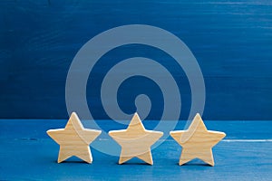 The rating of the hotel, restaurant, mobile application. Three stars on a blue background. The concept of rating and evaluation. Q