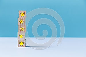 Rating for service quality. Customer experience concept. Wooden blocks. Crossed out stars. Copy space. Isolated on blue