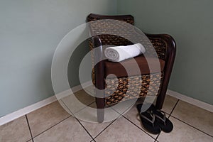 Rattan Armchair With Clean Towel And Shower Slippers