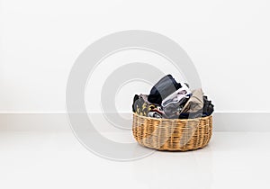 Rattan basket for clothes storage with white wall background inside bedroom.