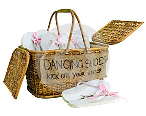 Rattan basket with white flip-flops with pink ribbon bows for guests, with a writing DANCING SHOES. KICK OFF YOUR HEELS!