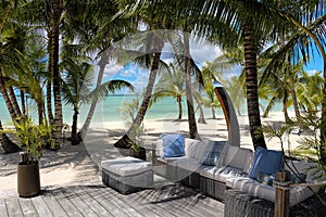 Rattan chairs on a wooden deck near the beach