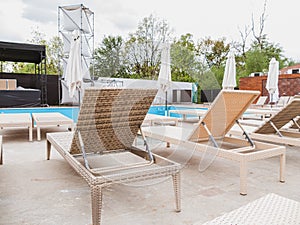 Rattan reclining chaise. Comfortable outdoor patio wicker chaise lounges. Swimming pool backyard resort furniture