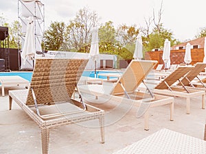 Rattan reclining chaise. Comfortable outdoor patio wicker chaise lounges. Swimming pool backyard resort furniture