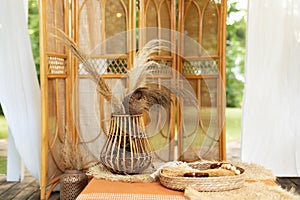 Rattan Vase with bouquet of dried floral, spikelets, ears and plants.