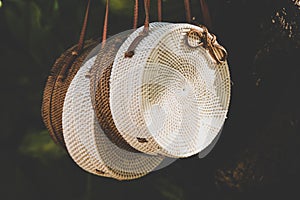 Rattang bags hanging on a tropical tree. Bali island. Organic material. Ecobag.