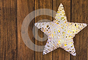 Rattans shining white Christmas star on weathered plank wood background, copy space for text, template for greeting card photo