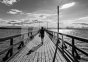 Rattvik, Dalarna - Sweden - Woman walking the straight lines of the Silvjan lake pier photo