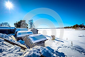 Rattvik - March 30, 2018: Wooden houses by the frozen lake Siljan in Rattvik, Dalarna, Sweden photo