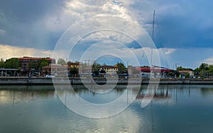 Ravenna, Italy: 10-04-2022: Beautiful buildings reflection on Ravenna`s darsena on a morning sunny day .