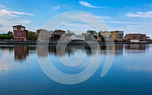 Ravenna, Italy: 10-04-2022: Beautiful buildings reflection on Ravenna`s darsena on a morning sunny day .