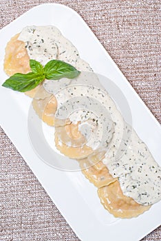 Ravioli with cream sauce on a white plate