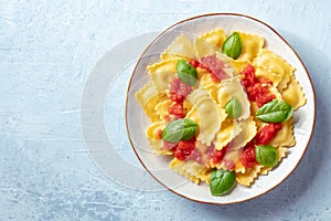 Ravioli with red tomato sauce and basil, top shot with copy space