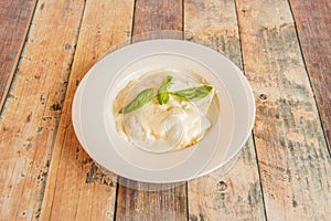 Ravioli stuffed with cheese covered with bÃ©chamel sauce and basil leaves
