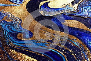 Ravishing blue and golden acrylic liquid ink swirl abstract background.