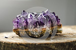 Raw amethyst rock with reflection on natural wood crystal ametist