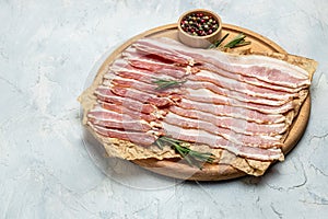 Raw bacon, bacon strips meat slice thin slicing pork fat meal on a light background, ketogenic diet, place for text, top view