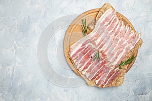 Raw bacon, bacon strips meat slice thin slicing pork fat meal on a light background, ketogenic diet, place for text, top view