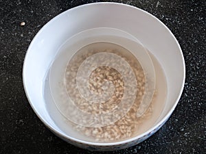 Raw barley groats in a bowl of water