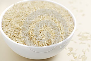 Raw basmati rice in a white bowl on a light background. Concept of Water-Conserving Products. Saving water.