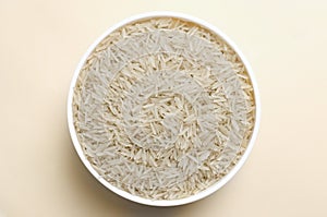 Raw basmati rice in a white bowl on a light background. Concept of Water-Conserving Products. Saving water.