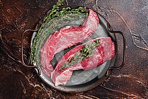 Raw Bavette or Sirloin flap beef meat steak with thyme. Dark background. Top view