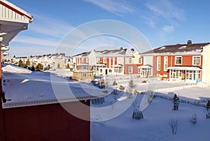Raw of beautiful colorful houses in family village in winter time on blue clear sky background