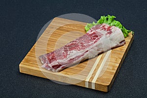 Raw beef bacon over wooden board