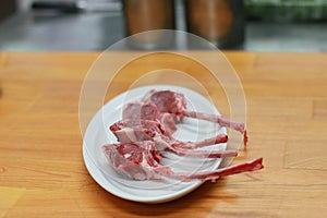 Raw beef bone rib-eye steak on a plate and wooden table