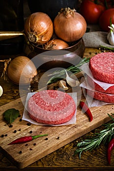 Raw beef burger, traditional barbecue, still life with vegetables and meat