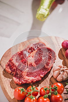 Raw beef on a cutting board with spices and ingredients for coo