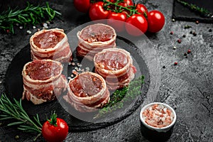 Raw beef filet Mignon steak on metel tray with pepper and salt, filet mignon. beef tenderloin steaks wrapped in bacon and thyme on