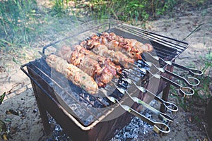 Raw beef kebabs cut into pieces and on a metal wire. Top view shot of red meat.